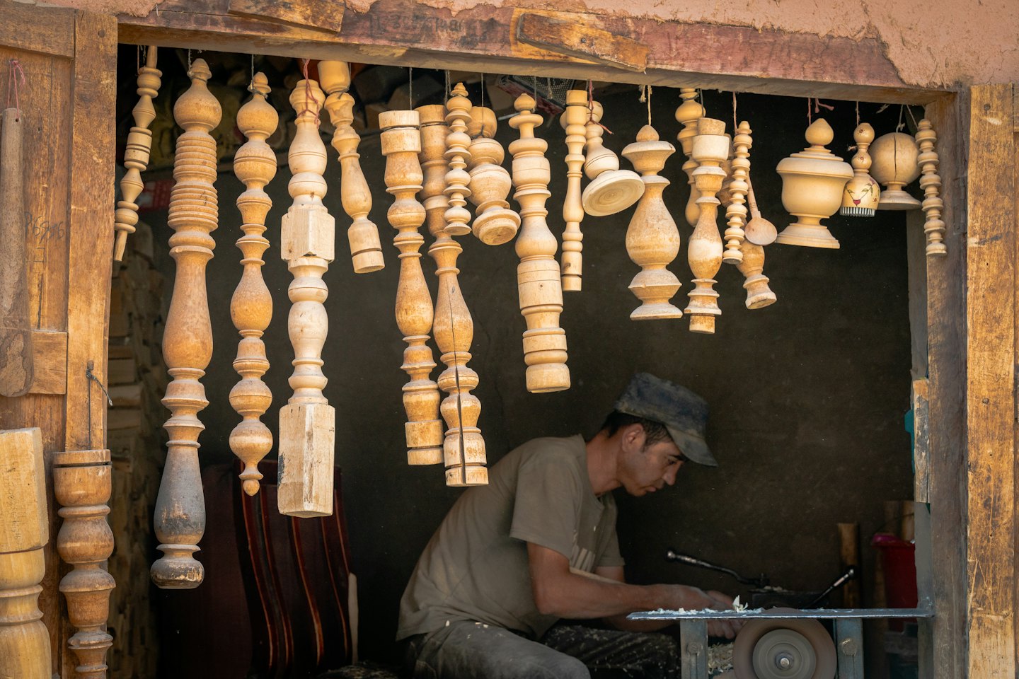 Artigiano che lavora un fuso di legno al tornio in laboratorio.
